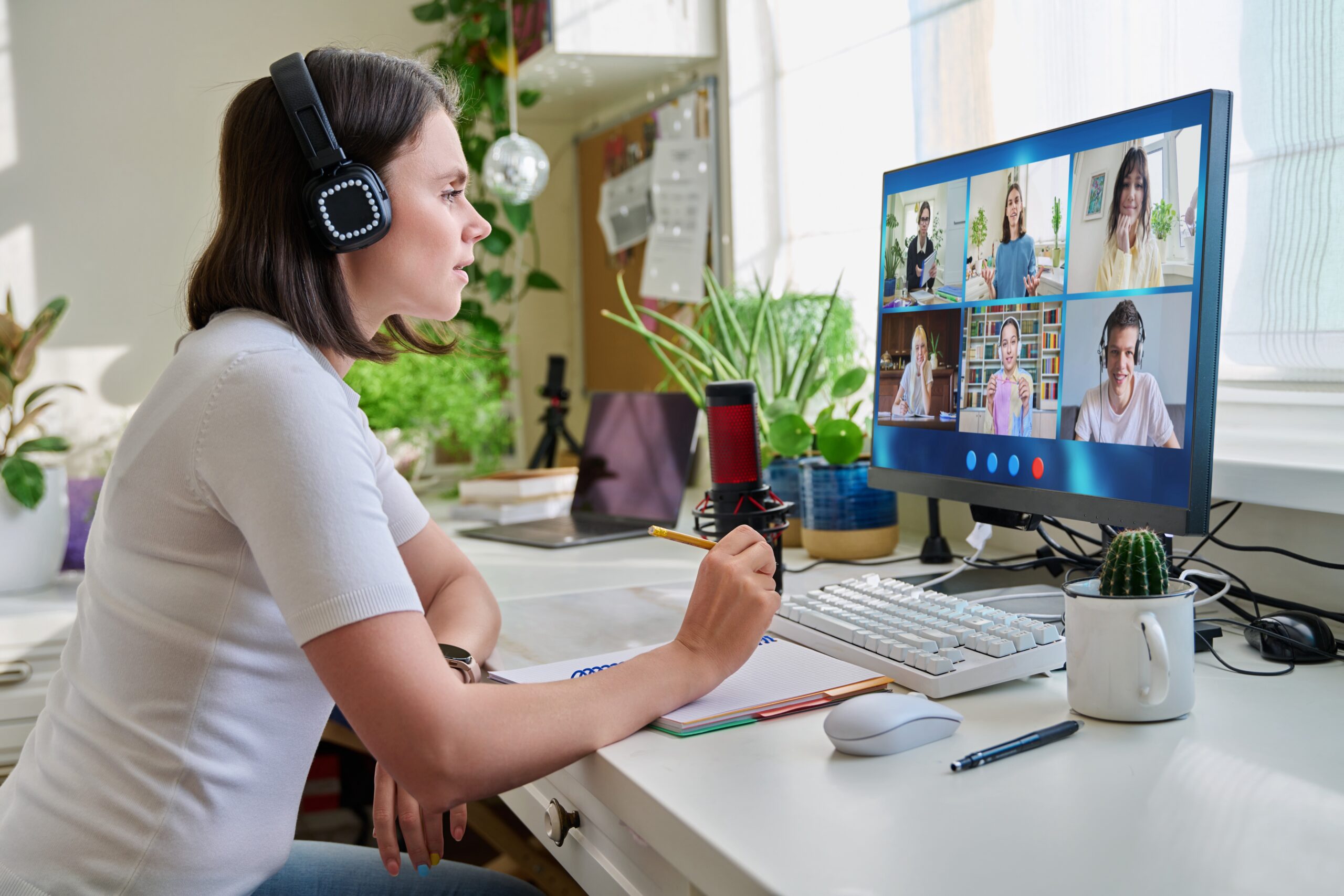 A woman wearing headphones is sitting at her desk